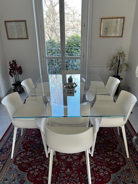 Tavolo da pranzo in vetro trasparente con sedie bianche